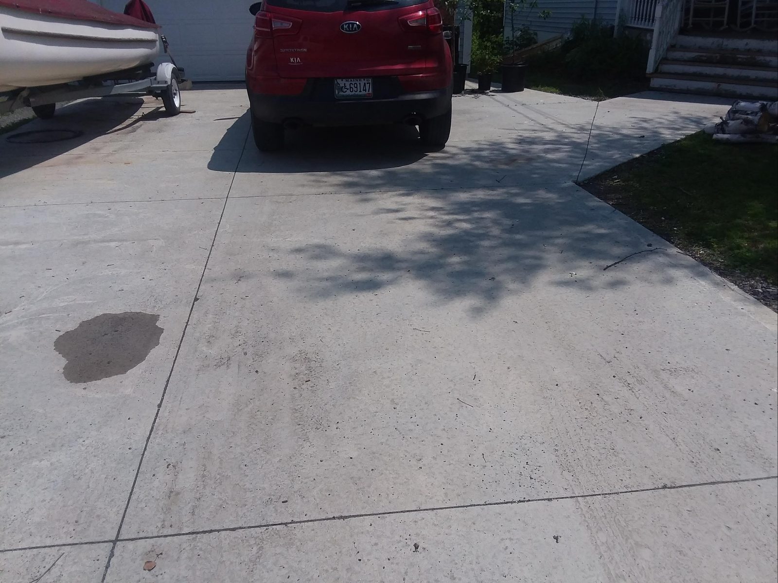 Completed residential concrete driveway with a car parked on it showing finished surface